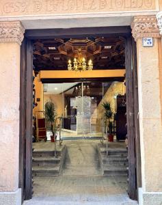 a entrance to a building with a chandelier and stairs at Hotel Boutique Casón De Los López in Toledo