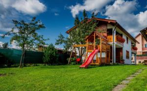 a house with a red slide in the yard at Apartment Roháčik in Zuberec