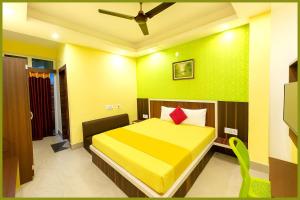 1 dormitorio con cama amarilla y almohada roja en Jagannath Temple Shashi Palace Resort - Fully Air conditioned# Free Wifi And Room Service #Budget Class Best Hotel IN Puri, en Puri