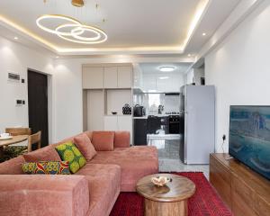 un salon avec un canapé marron et une cuisine dans l'établissement Diamond Ivy Two Bedroom Apartment, Swimming pool, gym, workspace ,Wonderiss Homes Kileleshwa Living, à Nairobi