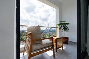 une pièce avec une chaise et une grande fenêtre dans l'établissement Diamond Ivy Two Bedroom Apartment, Swimming pool, gym, workspace ,Wonderiss Homes Kileleshwa Living, à Nairobi