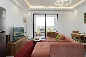 un salon avec un canapé et une télévision dans l'établissement Diamond Ivy Two Bedroom Apartment, Swimming pool, gym, workspace ,Wonderiss Homes Kileleshwa Living, à Nairobi