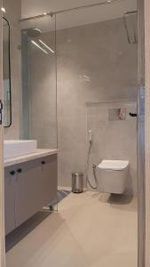 Un baño con inodoro y ducha de cristal. en Hotel HPB Grand, en Bhadohī