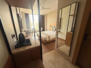 una habitación de hotel con una cama y un espejo en Hotel HPB Grand, en Bhadohī