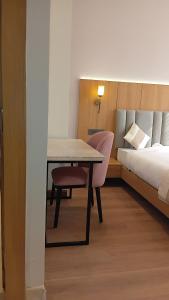 Habitación con cama, mesa, cama y falda en Hotel HPB Grand, en Bhadohī