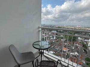 a balcony with a table and chair and a view at The Haven Room at Mataram City Apartment - Yudhistira Tower in Kejayan
