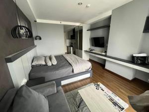 a small bedroom with a bed and a couch at The Haven Room at Mataram City Apartment - Yudhistira Tower in Kejayan