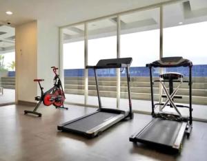 a gym with three exercise bikes and a treadmill at The Haven Room at Mataram City Apartment - Yudhistira Tower in Kejayan +1 photo