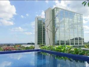 a view of a building from a swimming pool at The Haven Room at Mataram City Apartment - Yudhistira Tower in Kejayan