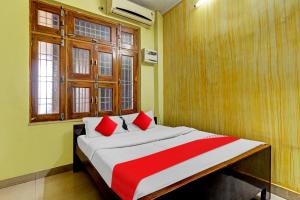 une chambre avec un grand lit avec des oreillers rouges dans l'établissement Hotel O Royal, à Gwalior 17 autres photos