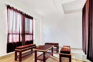 une chambre avec deux chaises, une table et une fenêtre dans l'établissement Hotel O Royal, à Gwalior