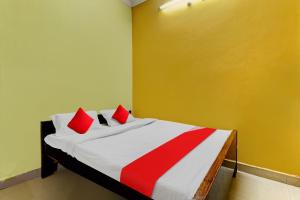 une chambre avec un lit avec des oreillers rouges dessus dans l'établissement Hotel O Royal, à Gwalior