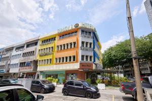 a building with cars parked in a parking lot at Hotel Sunjoy9 OKR Near Midvalley 10 Mins Only in Kuala Lumpur