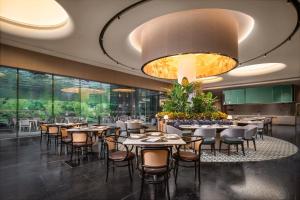 ein Restaurant mit Tischen und Stühlen und einem großen Kronleuchter in der Unterkunft Holiday Inn Resort Ningbo Ninghai by IHG in Ninghai