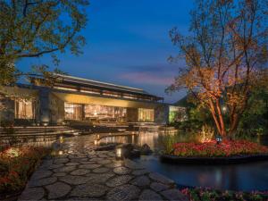 ein Gebäude mit einem Teich davor in der Unterkunft Holiday Inn Resort Ningbo Ninghai by IHG in Ninghai