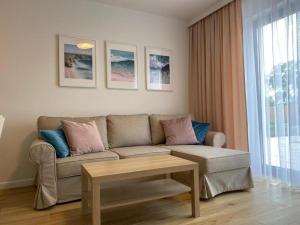 un salon avec un canapé et une table dans l'établissement Holiday house for 4 people, peace and quiet, à Grzybowo