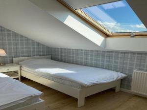 une chambre avec deux lits et une lucarne dans l'établissement Holiday house for 4 people, peace and quiet, à Grzybowo 43 autres photos