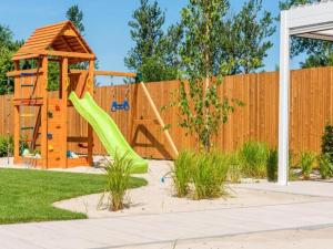 une aire de jeux avec toboggan et clôture en bois dans l'établissement Holiday house for 4 people, peace and quiet, à Grzybowo