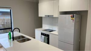 eine Küche mit einem weißen Kühlschrank und einer Spüle in der Unterkunft The Tamarind Retreat-Spacious home in Park Ridge in Park Ridge + 9 Fotos