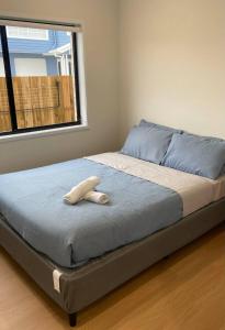 ein Bett in einem Zimmer mit einem großen Fenster in der Unterkunft The Tamarind Retreat-Spacious home in Park Ridge in Park Ridge