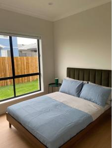 ein Schlafzimmer mit einem großen Bett mit einem großen Fenster in der Unterkunft The Tamarind Retreat-Spacious home in Park Ridge in Park Ridge