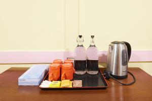two bottles of wine sitting on a tray next to a toaster at Hotel Sunjoy9 OKR Near Midvalley 10 Mins Only in Kuala Lumpur