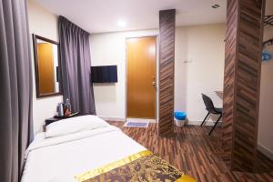 a hotel room with a bed and a desk and a door at Hotel Sunjoy9 OKR Near Midvalley 10 Mins Only in Kuala Lumpur