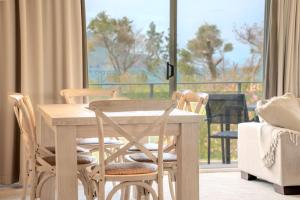 una mesa y sillas con vistas a un balcón en The Helm Unit 1 22 Voyager Close, en Nelson Bay