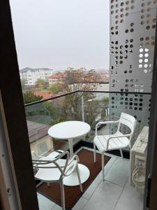 ein Balkon mit Tisch und Stühlen und Aussicht in der Unterkunft Studio One Cassas Residence in Craiova
