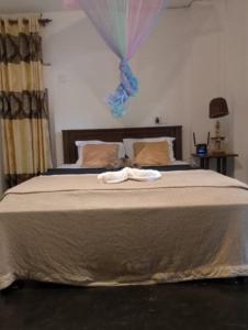 Una cama con una toalla encima. en Sihe House, en Ahangama