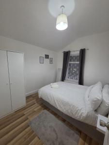 a white bedroom with a bed and a mirror at Modern 4 bedroom house in Belvedere in Erith