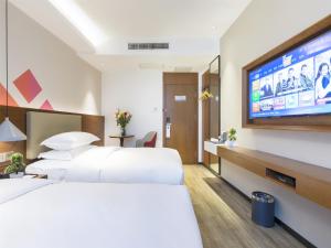 ein Hotelzimmer mit zwei Betten und einem Flachbildfernseher in der Unterkunft Borrman Hotel Guangzhou East Station Meihuayuan Subway Station Branch in Guangzhou + 19 Fotos