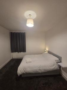 a bedroom with a white bed and a light at Modern 4 bedroom house in Belvedere in Erith