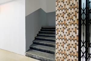 a staircase in a building with a tile wall at FabHotel Lorwen in Hyderabad