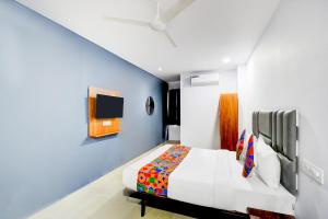 a bedroom with a bed and a tv on the wall at FabHotel Lorwen in Hyderabad