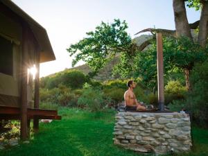 a man sitting on top of a stone wall at Majestic wonders in Knysna