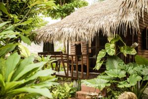 eine Hütte mit Stühlen und Strohdach in der Unterkunft Hideaway, Koh Lipe in Ko Lipe