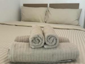 two towels are stacked on a bed in a bedroom at SIAM LOUNGE - Pratumnak in Pattaya South