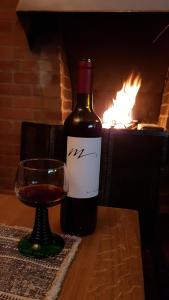 eine Flasche Wein und ein Glas auf dem Tisch in der Unterkunft Gemütliches Chalet zum Alleinbewohnen mit Top Garten & Bergblick, kostenloses WIFI, Ladestation für E-Autos in Grindelwald