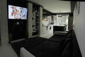 a living room with a tv on a wall at Black&White Deluxe in Miskolc