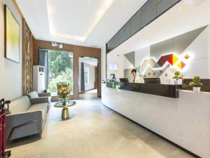 eine Bürolobby mit einer Rezeption und einer Person in der Unterkunft Borrman Hotel Guangzhou East Station Meihuayuan Subway Station Branch in Guangzhou