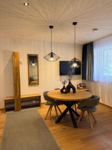 a dining room with a table and chairs and lights at see.view apartment in See