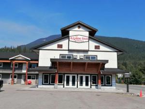 un grand bâtiment avec une enseigne indiquant « Airport Inn » dans l'établissement Alpine Inn & Suites, à Revelstoke