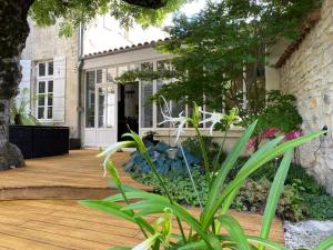 a porch of a house with a wooden deck at Le Relais d'Angély in Saint-Jean-dʼAngély
