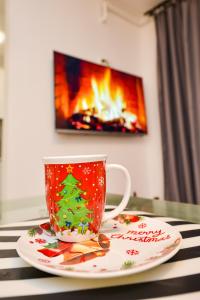 a christmas coffee cup on a plate with a christmas tree on it at CityScape Bucharest in Bucharest