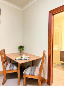 uma mesa de madeira com 2 cadeiras e uma mesa com um lavatório em Whispering Pines em Kaihinu mais 11 fotografias