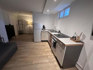 a kitchen with a stove and a sink and a refrigerator at Montage- Pendlerwohnung in Kandern +4 photos