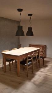 a dining room table with chairs and two lights at Biala Biobergün in Bergün