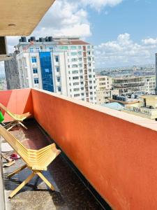 2 Stühle auf einem Balkon mit Stadtblick in der Unterkunft Exclusive 3BR City Escape High End Comfort & Stunning Views in Daressalam + 16 Fotos