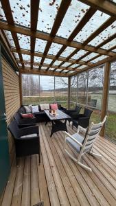 a patio with a couch and chairs on a wooden deck at Private House with Sauna and Winter Garden in Helsinki